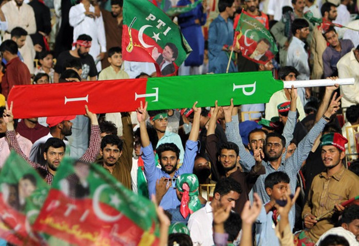supporters of former prime minister imran khan hold a giant cricket bat with the colours and initials of the party in multan on july 20 2018 photo afp file