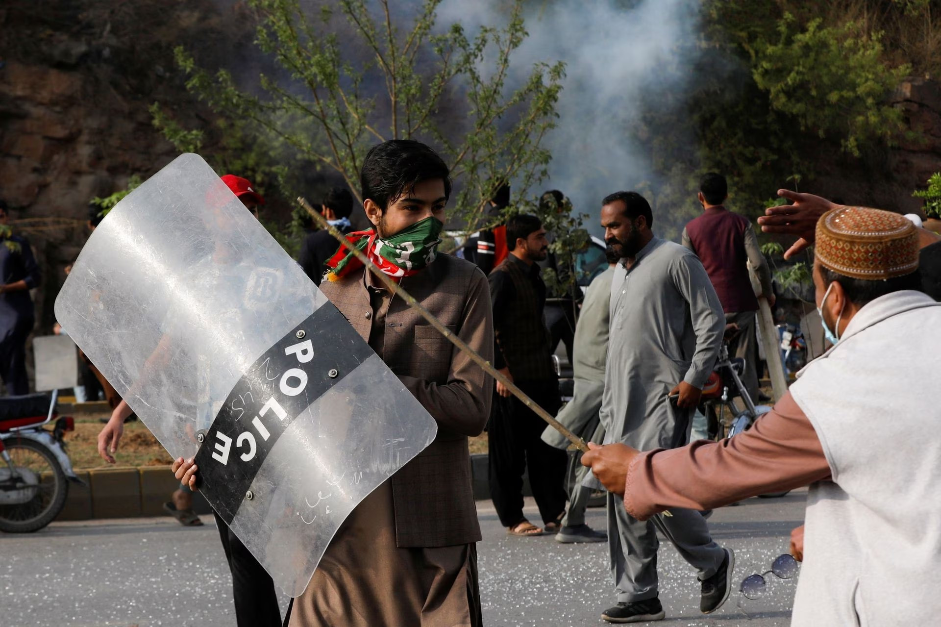a supporter of former prime minister imran khan walks with a riot shield used by the police during a clash outside the federal judicial complex in islamabad pakistan march 18 2023 photo reuters