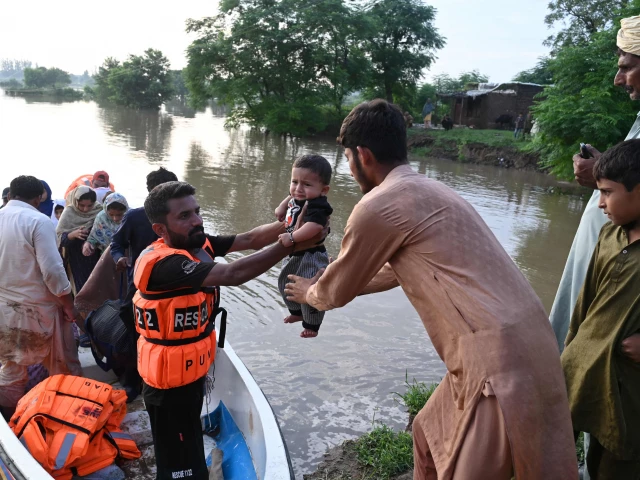 rescuers in a small boat hand over a baby as they evacuate residents from the flooded area of narowal a city of punjab on august 27 2025 photo afp rescuers in a small boat hand over a baby as they evacuate residents from the flooded area of narowal a city of punjab on august 27 2025 photo afp