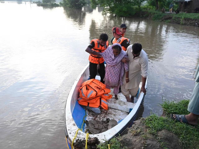 rescuers in a small boat evacuate residents from the flooded area of narowal a city of punjab on august 27 2025 photo afp