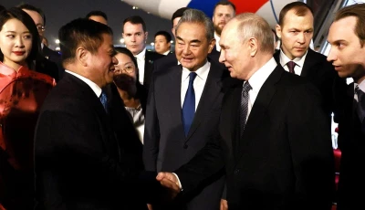 russia s president vladimir putin shakes hands with china s ambassador to russia zhang hanhui as foreign minister wang yi stands nearby during a welcoming ceremony at an airport in beijing china may 19 2026 sputnik via reuters