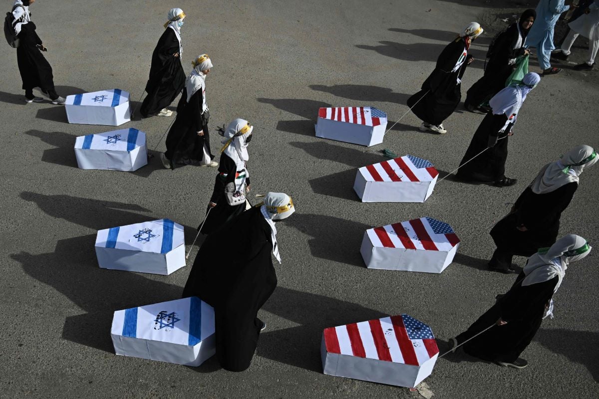 Pakistani women drag coffins wrapped with the national flags of US and Israel, during a rally to mark Al-Quds Day (Jerusalem), a commemoration held annually on the last Friday of the Islamic holy fasting month of Ramadan, in Karachi on March 13, 2026. PHOTO:AFP