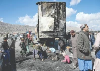 people gather as others collect recyclable items beside a burnt vehicle along a road on the outskirts of quetta a day after coordinated terror attacks in balochistan photo afp