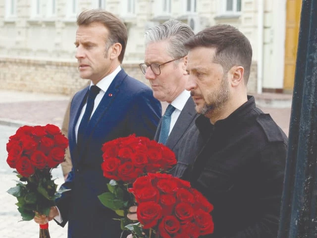 ukrainian president volodymyr zelenskiy french president emmanuel macron and british prime minister keir starmer hold flowers as they visit a memorial wall of fallen ukrainian servicemen in kyiv photo reuters ukrainian president volodymyr zelenskiy french president emmanuel macron and british prime minister keir starmer hold flowers as they visit a memorial wall of fallen ukrainian servicemen in kyiv photo reuters
