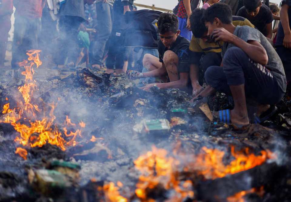 palestinians search for food among burnt debris in the aftermath of an israeli strike on an area designated for displaced people in rafah in the southern gaza strip may 27 2024 photo reuters