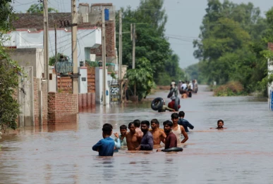 residents wade through a flooded road following monsoon rains and rising water levels in qadirabad village near the chenab river in punjab province pakistan august 28 2025 photo reuters