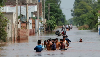 residents wade through a flooded road following monsoon rains and rising water levels in qadirabad village near the chenab river in punjab province pakistan august 28 2025 photo reuters