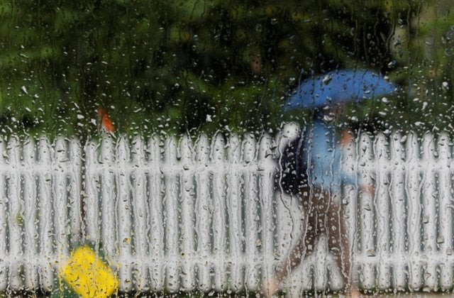 a pedestrian under an umbrella passes a rain covered car window photo reuters a pedestrian under an umbrella passes a rain covered car window photo reuters