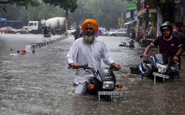 a man on his motorbike wades through a flooded street after heavy rains in new delhi india july 8 2023 reuters anushree fadnavis