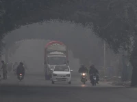 commuters ride along a street amid dense smog in lahore on november 1 2025 photo afp