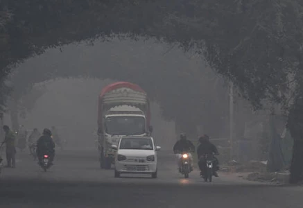 commuters ride along a street amid dense smog in lahore on november 1 2025 photo afp