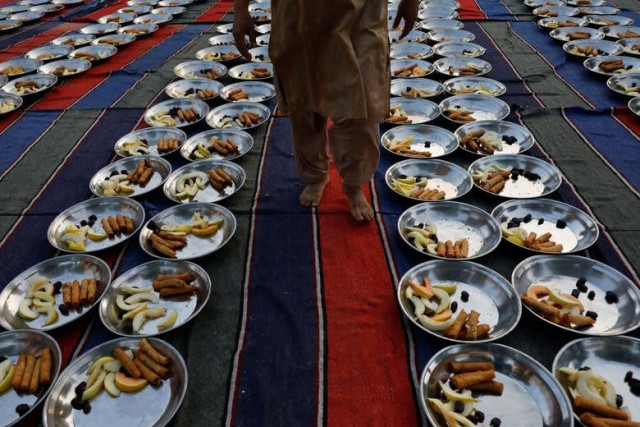 a man walks to inspect food panes before iftar during the fasting month of ramazan in karachi photo reuters a man walks to inspect food panes before iftar during the fasting month of ramazan in karachi photo reuters