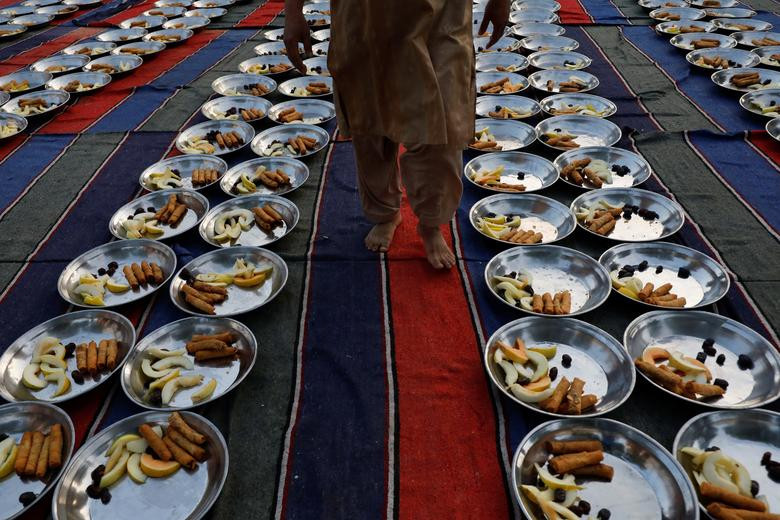 a man walks to inspect food panes before iftar during the fasting month of ramazan in karachi photo reuters