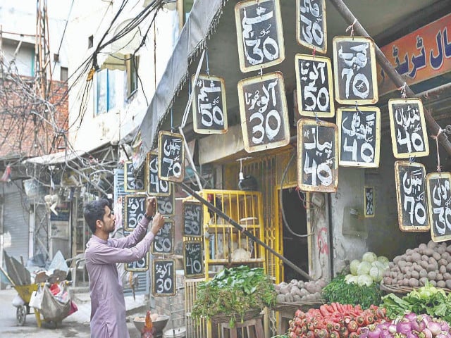 a greengrocer displays vegetable prices outside his shop at chowk rustam park in lahore photo app