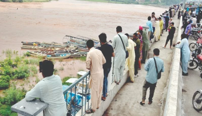 citizens gather at the ravi river bridge in lahore to view floodwater authorities have cautioned residents to avoid travel in areas facing a flood risk photo nni