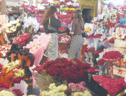 customers throng a flower stall selecting bouquets heart shaped arrangements and gift hampers on valentine s day in the federal capital photo online