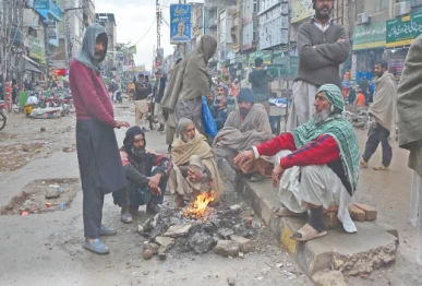 labourers in rawalpindi gather around a fire to keep warm during rainy weather while waiting for customers to hire them for daily wage work to support their families photo online
