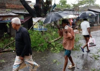 people walk past a fallen tree branch as cyclone remal hits the country in the shyamnagar area of satkhira bangladesh may 27 2024 photo reuters