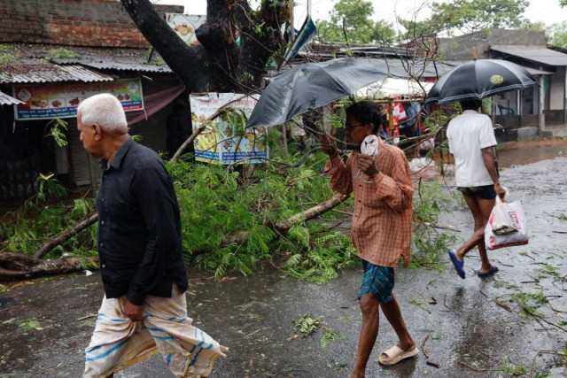 people walk past a fallen tree branch as cyclone remal hits the country in the shyamnagar area of satkhira bangladesh may 27 2024 photo reuters people walk past a fallen tree branch as cyclone remal hits the country in the shyamnagar area of satkhira bangladesh may 27 2024 photo reuters