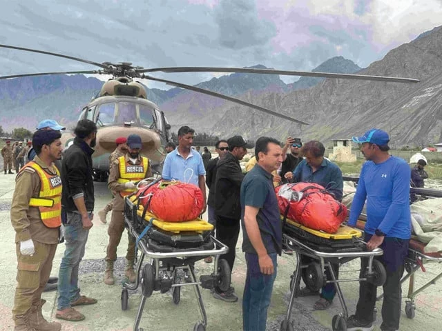 rescue personnel carry the bodies of deceased climbers upon arrival at a military base in skardu rescue personnel carry the bodies of deceased climbers upon arrival at a military base in skardu