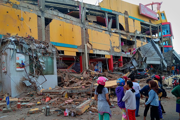 Residents stand in front of a damaged shopping mall PHOTO REUTERS