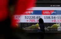 a pedestrian walks past a stock quotation board showing the nikkei share average and the exchange rate between the us dollar and japanese yen outside a brokerage in tokyo japan on march 24 2026 photo reuters