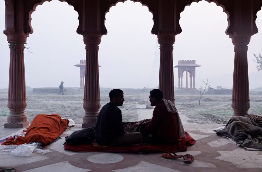 men talk to each other on the banks of the rive yamuna on a smoggy morning in new delhi india november 13 2023 reuters anushree fadnavis acquire licensing rights