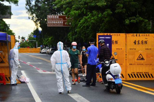 a delivery courier places food near a barricade at an entrance to a residential compound amid lockdown measures to curb the coronavirus disease covid 19 outbreak in sanya hainan province china china daily via reuters a delivery courier places food near a barricade at an entrance to a residential compound amid lockdown measures to curb the coronavirus disease covid 19 outbreak in sanya hainan province china china daily via reuters
