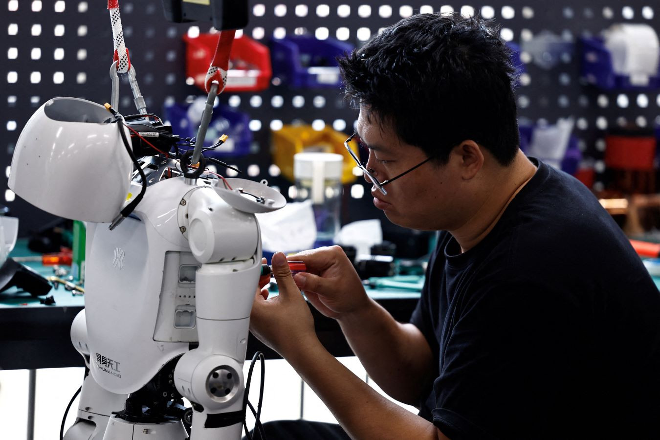 FILE PHOTO: An engineer works on a Tiangong Omni humanoid robot in the research and testing area of the Beijing Humanoid Robot Innovation Center, also known as X-Humanoid, in Beijing, China, September 4, 2026. REUTERS