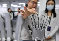 a man touches a robotic hand displayed at the demonstration area at the office of linkerbot in beijing china april 27 2026 reuters