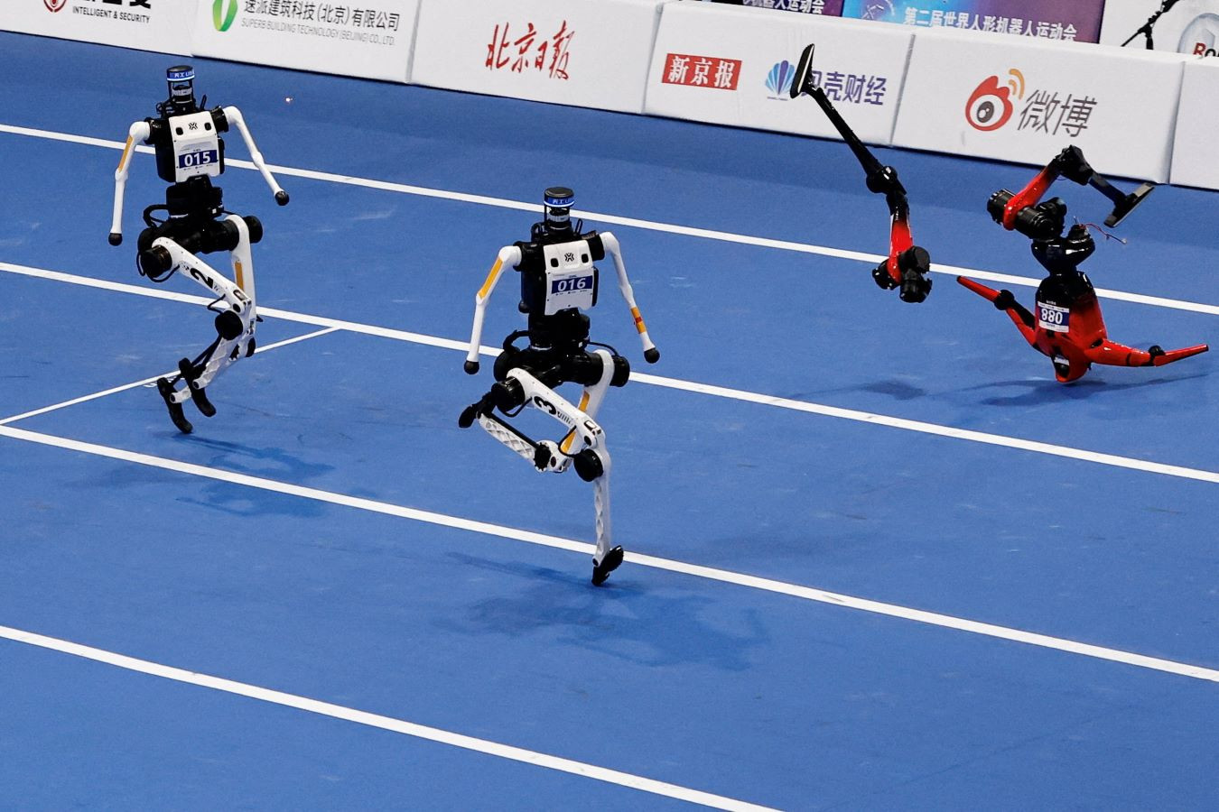 An Honor humanoid robot falls apart next to Tiangong humanoid robots during a 100m large size group semifinals, at the 2026 World Humanoid Robot Games at the National Speed Skating Oval in Beijing, China, on August 25, 2026. REUTERS