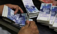 an employee counts pakistani rupee notes at a bank in peshawar on august 22 2023 photo reuters