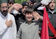 the son of martyred sp akbar khan shinwari raises his hand in salute at his father s grave photo app