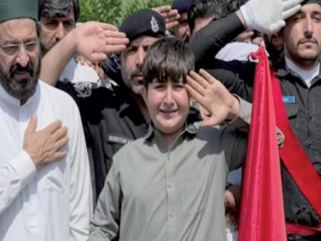 the son of martyred sp akbar khan shinwari raises his hand in salute at his father s grave photo app the son of martyred sp akbar khan shinwari raises his hand in salute at his father s grave photo app