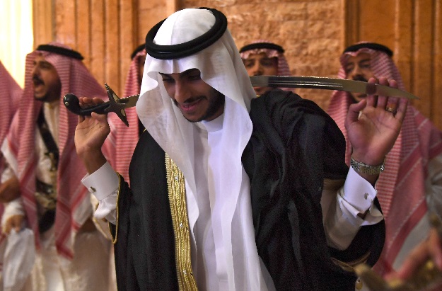 Saudi groom Basil Albani holds a traditional sword and dances with his friends during his wedding at his home in the Red Sea resort of Jeddah on September 6, 2018. - It was a Saudi wedding like any other -- clutching a decorative sword, the groom bobbed and swayed in a traditional dance. PHOTO: AFP