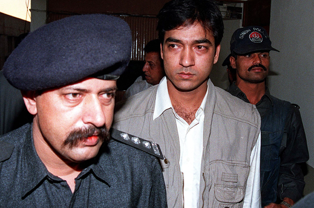 In this file photo taken on July 5, 1997, a police officer inspects the bullet-riddled car of Shahid Hamid, managing director of the state-run Karachi Electric Supply Corporation (KESC), who was killed along with his driver and guard by unidentidied gunmen in Karachi. 