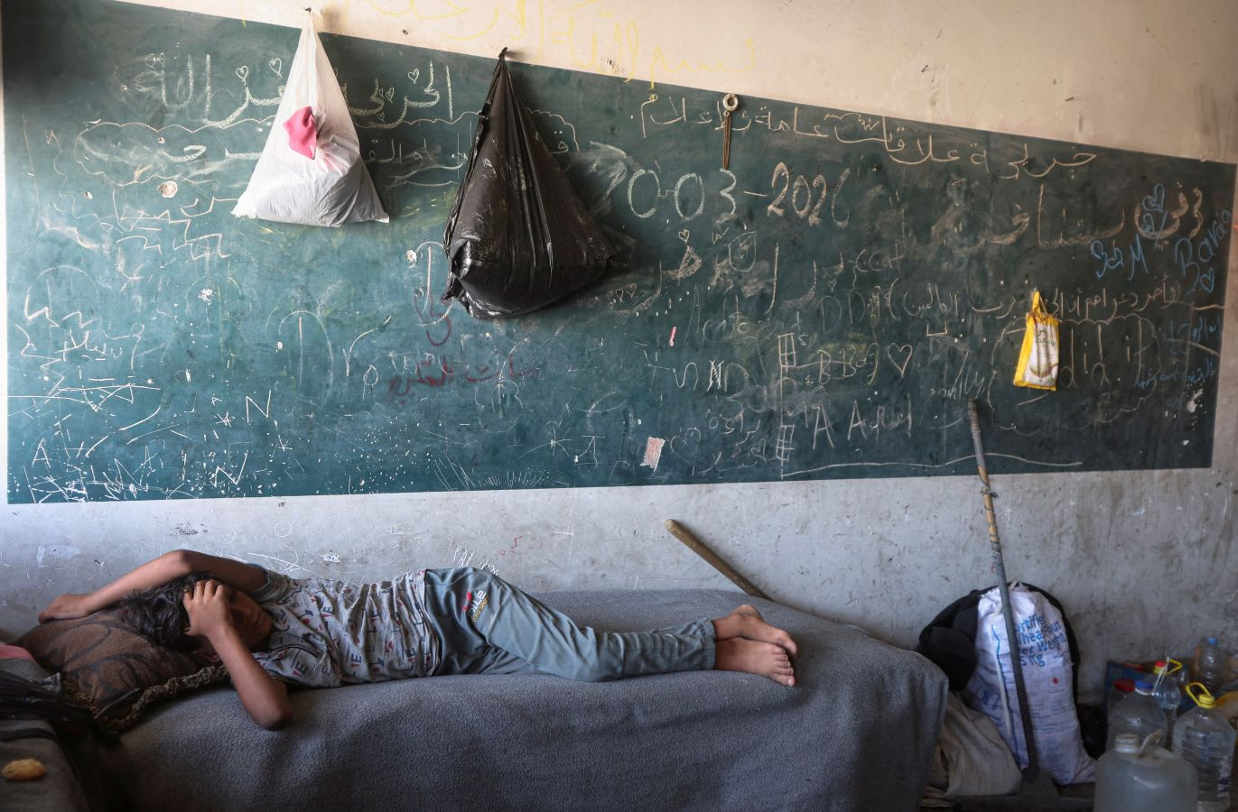 A displaced Palestinian child lies inside a classroom-turned-shelter in Khan Younis, in the southern Gaza Strip, September 10, 2026. REUTERS