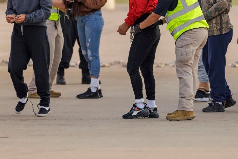 security personnel pat down shackled migrants detained by ice before boarding a repatriation flight on may 5 2023 in harlingen texas photo getty images