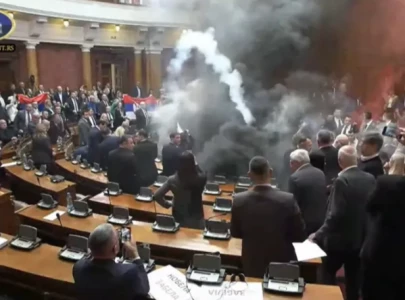 serbian parliament erupts in chaos as opposition throws smoke bombs