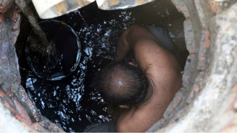 nearly naked and covered with a black foul smelling muck shafiq masih struggles out of a sewer he has just cleaned by hand in an upmarket district of lahore photo afp