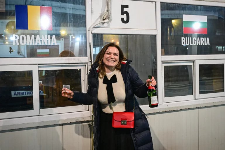 a bulgarian woman celebrates at a checkpoint at the giurgiu ruse border between romania and bulgaria on january 1 2025 photo afp