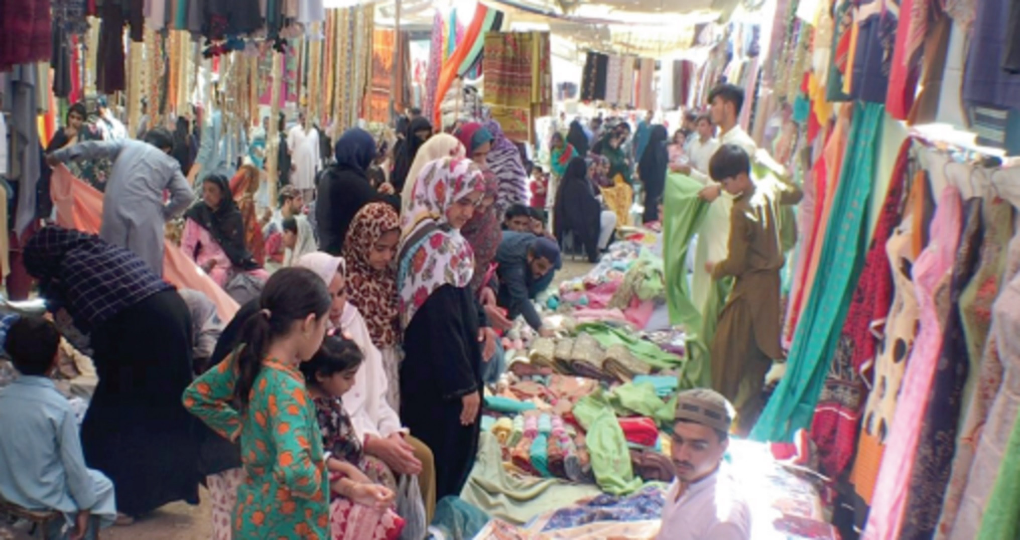 women select clothes at a stall at the gulshan e iqbal bachat bazaar on sunday photo express