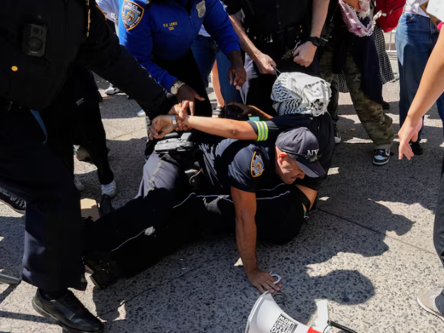 Photo: A pro-Palestinian protester is detained by NYPD officers outside of Barnard College, New York City/Reuters