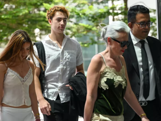 French teenager Didier Gaspard Owen Maximilien (2nd L) faces criminal charges in Singapore for a straw licking stunt © Roslan RAHMAN / AFP