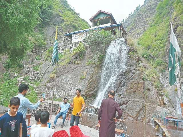 tourists gather in front of a waterfall in panjgir district muzaffarabad photo afp tourists gather in front of a waterfall in panjgir district muzaffarabad photo afp