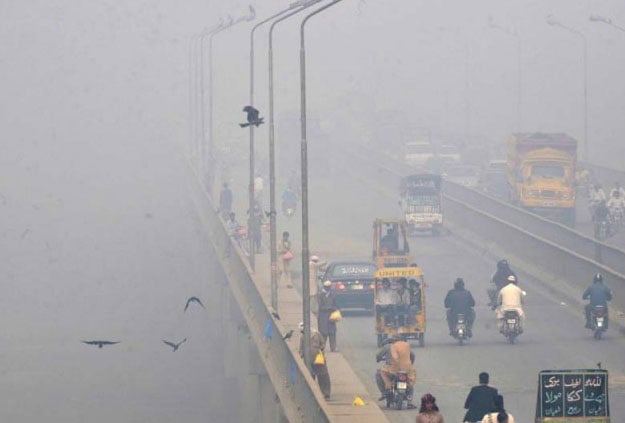 A Pakistani vendor carries baloons on a street amid heavy smog in Lahore. PHOTO: AFP