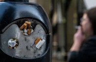 a smoker stands next to a bin for cigarette butts in london britain november 26 2024 photo reuters