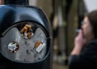 a smoker stands next to a bin for cigarette butts in london britain november 26 2024 photo reuters