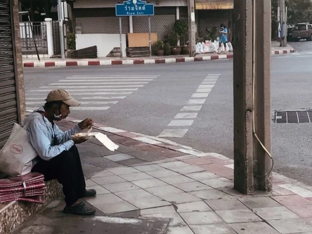 an informal sector worker eats by the roadside in bangkok photo un ilo an informal sector worker eats by the roadside in bangkok photo un ilo