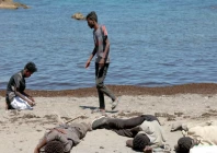 foreign land a migrant prays and others wait on the beach following mass crossings of migrants on foot and by sea from morocco into spanish territory in ceuta photo reuters